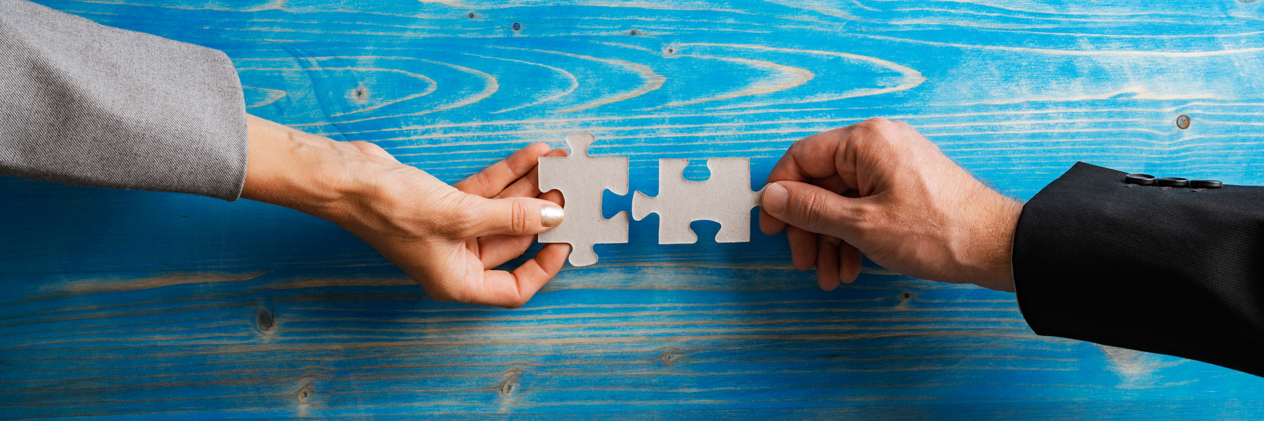 Hands Holding Puzzle Pieces That Fit Together 